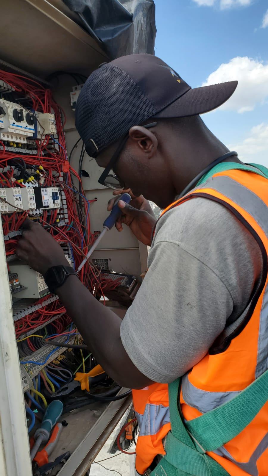 Technician wiring an industrial control panel on site