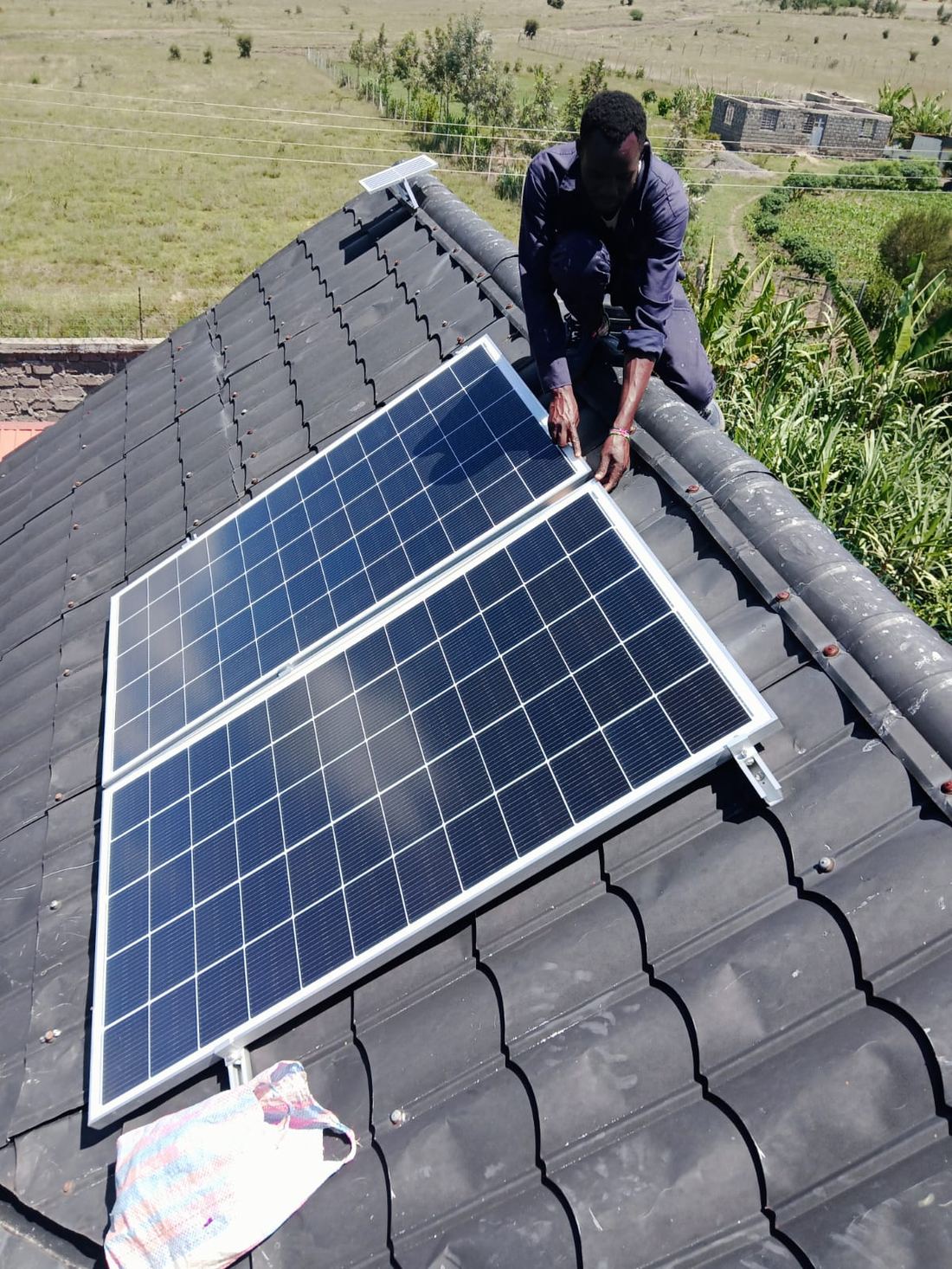 Technician mounting solar panels on a tiled roof